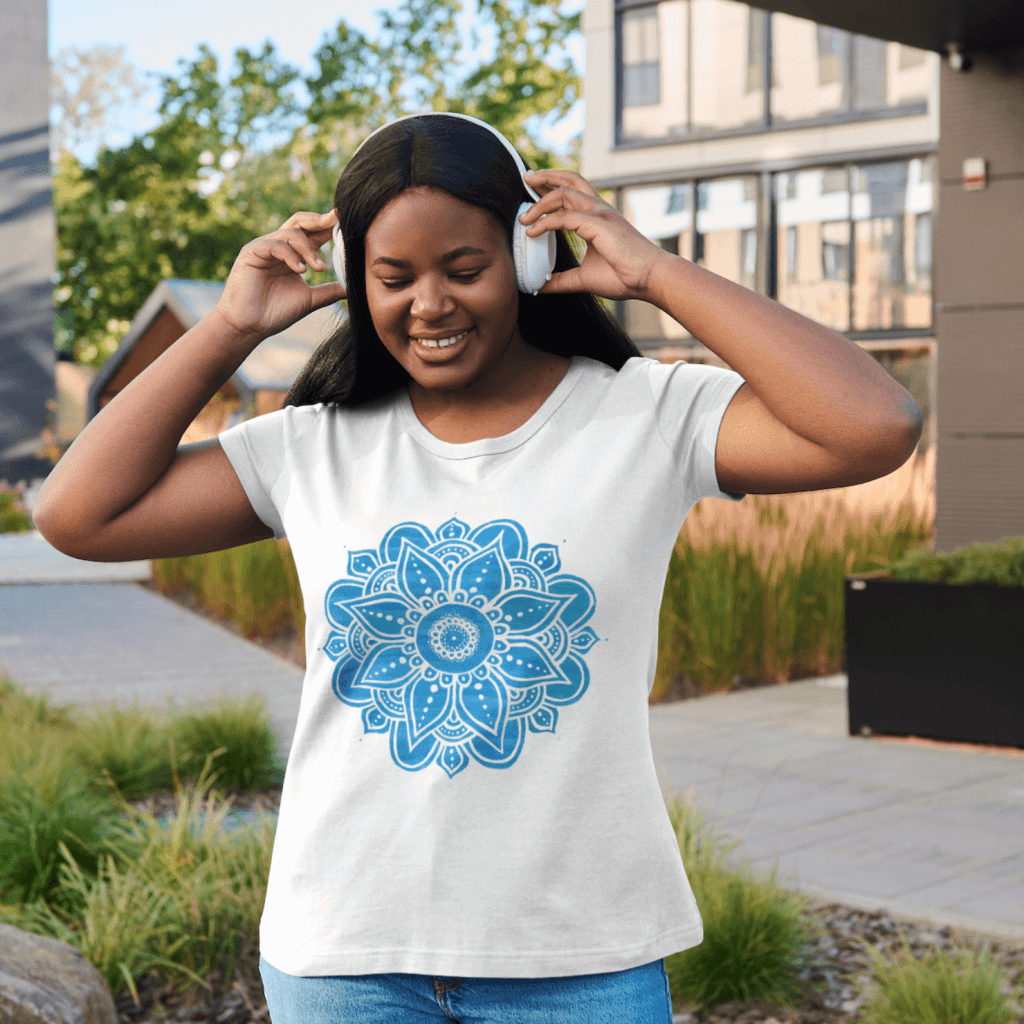 A girl with a tshirt showcasing a blue and white Mandala design.