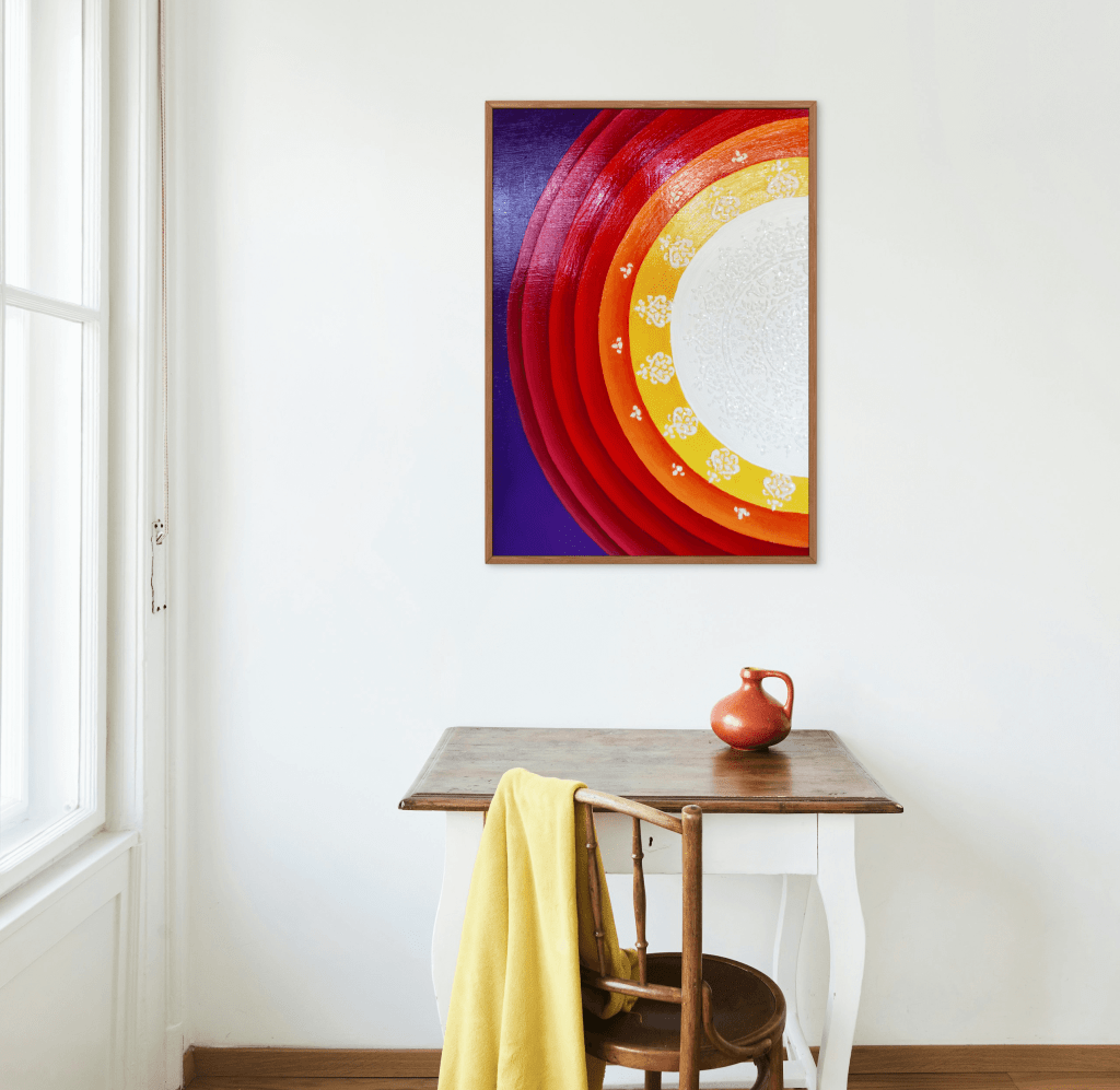 A painting on top of a table representing half sun mandala with feminine colors.