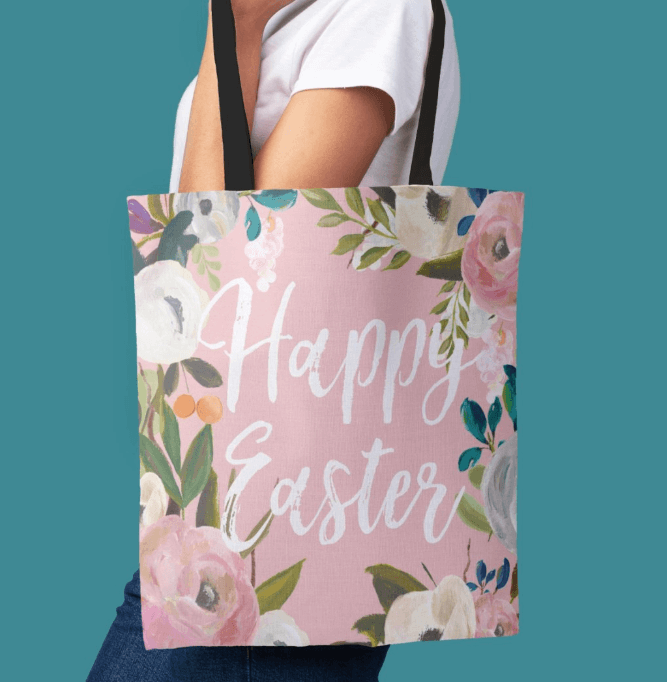 Easter Egg Hunt Tote Bag featuring beautiful florals on a pink background and a white script in the middle with Happy Easter.